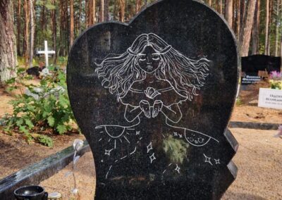 Гранитный памятник в форме сердца с гравировкой. Памятник установлен на гранитную ограду на кладбище Лийва в Таллинне.