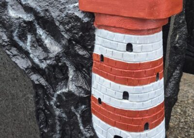 Эксклюзивный гранитный памятник в форме маяка красного цвета на скале. Ручная работа, мастерская Avrora Kivi в Таллине.