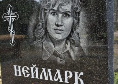 Вертикальный памятник из черного гранита с гравировкой портрета и православного креста, работа мастерской Avrora Kivi OÜ.